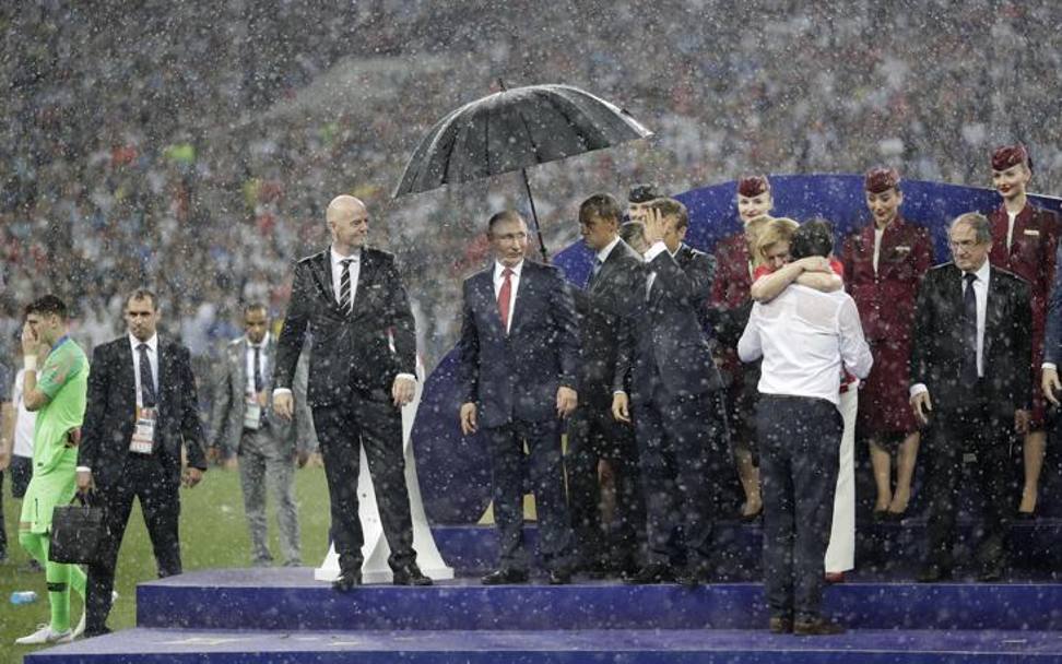 Macron, spazientito, si pettina sotto la pioggia. Ap